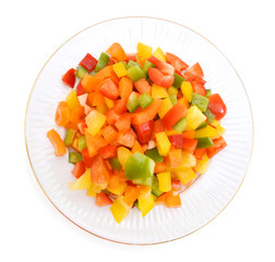 Yellow, red and green peppers Bulgarian. Slicing. Cubes in plate on white