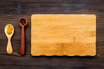 Cook a meal. Mock up for menu or recipe. Wooden cutting board near ingredients on dark wooden background top view