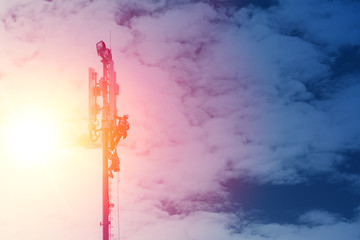 Technician working on communication tower on sunset blue sky