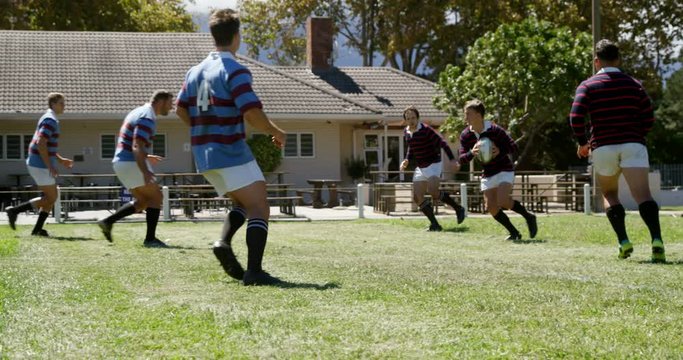 Rugby players try to defend oval ball from other team  