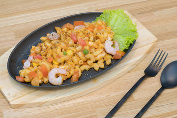 Stir Fried Macaroni with shrimp and chilli and tomato - penne pasta, serving on a wooden table.