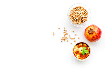 Middle Eastern cuisine. Bowls with hummus and chickpeas on white background top view copy space