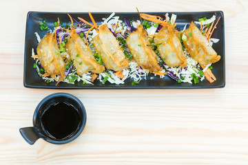 Gyoza , Guyza in black plate with soy sauce dumplings on wooden table, popular Japanese Food on Wooden Background. Top view Food with copy space.