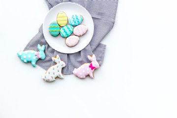 Easter background. Cookies in shape of easter bunny and easter eggs. White background top view space for text