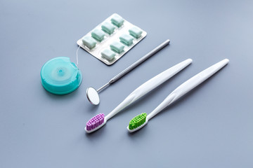 Tools for oral cavity hygiene. Brushes, floss, dental mirror, gum on blue background