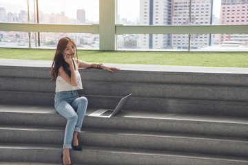 working women use phone and computer laptop sitting on stair