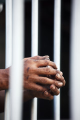 Obraz premium hand of prisoner in jail background.