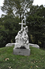 Fototapeta premium Statue of Two Angel Children with a Cross in a Cemetery