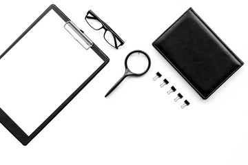 Monochrome white and black work desk with pad, notebook, glasses on white background top view copy space mock up