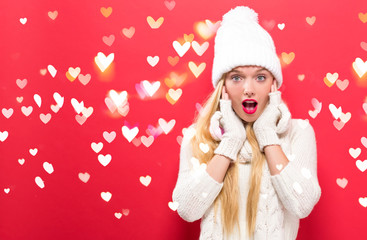 Young woman in winter clothes with heart lights