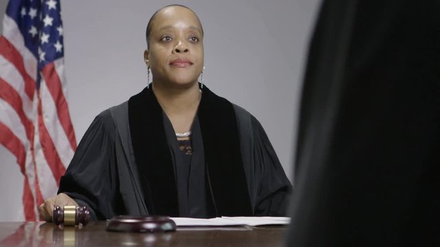 Female African American judge lowering a gavel in courtroom