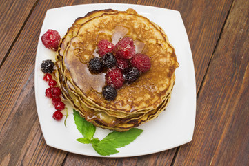 Delicious pancakes with berries and maple syrup. Top
