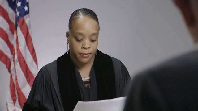 Female African American judge reading papers in court room