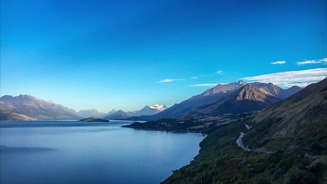 Wakatipu Lake Sunrise time lapse with the mountains slowly lighten up by the first sun rays of the day -Amazing View from Bennett's Bluff Lookout in New Zealand.