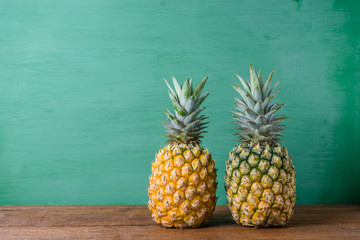 Ripe pineapples on a wooden table background.