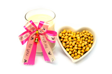 Glass soy milk width ribbon and Soy bean in heart shape isolated on white background, food and drink healthy concept, valentine festival