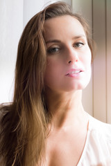 Naklejka premium Pretty woman portrait at the window