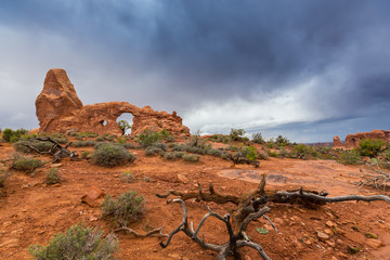 Storm clouds, rain, and red geologic sandstone structures in the Utah desert, Arches National Park
