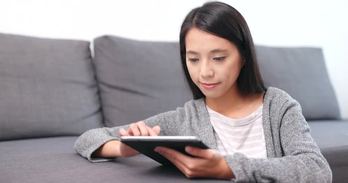 Woman using tablet computer at home