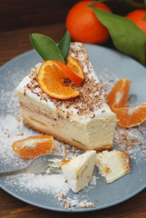 Piece of Delicious Cheesecake with Tangerine on Gray Plate and Dark Wooden Background. Vertical Image.