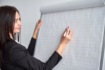 close up of woman with marker writing or drawing something on flip chart