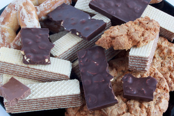 Chocolate and other sweets are lying on a black plate.