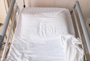 Fototapeta na wymiar Empty bed on hospital room