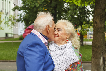 Black and white photo. Elderly man kisses an elderly lady. Concept: family, love, date. Fancy...