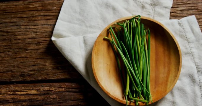 Fresh garlic chives in wooden plate 