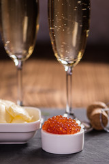 Side view of caviar and champagne on wood table 
