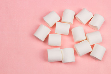 Marshmallows on pink pastel background.