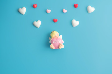 Valentines heart and cute little cupid on a blue color background.Happy Valentines Day background. Can be used for celebrations valentines day.