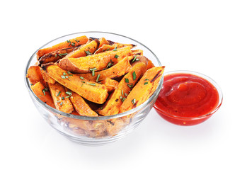 Baked sweet potatoes and ketchup in glass bowl isolated on white background.