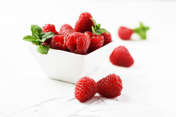 Sweet fresh raspberry on the white stone background