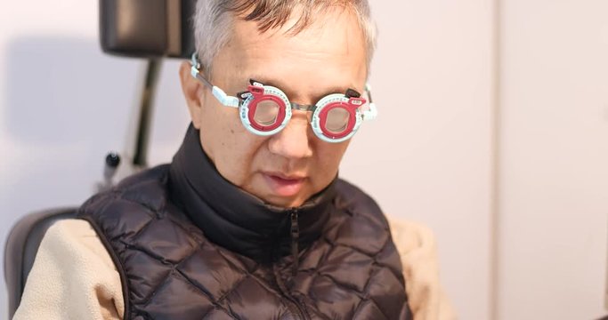 Asian senior man doing eye test