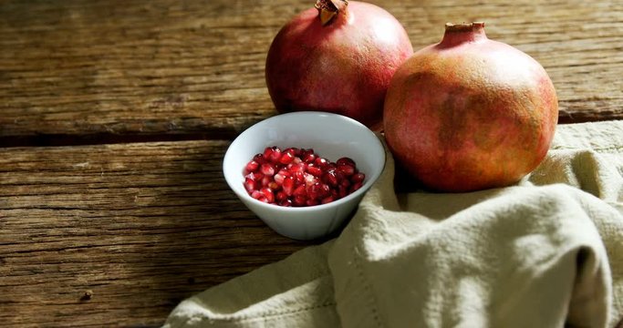 Pomegranate and napkin on wooden table 
