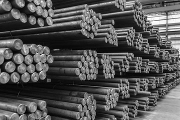 Rows of Steel Round Bar storage and stacking in the warehouse for industrial construction. Black...