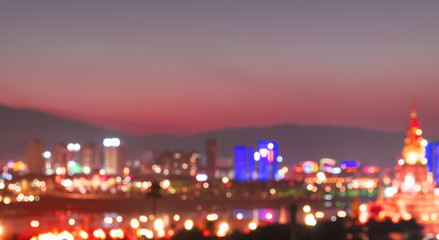 Abstract background from blurred business city center light at night with bokeh and blue sky
