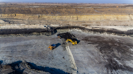 Coal section, Primorsky Krai, Russia - March 2017: chalk pit. Excavator pours soil into the truck