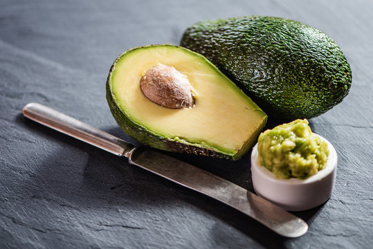 Avocado  On Black Stone Background Sliced And Puree