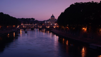 Obraz premium View of the St. Peter's Basilica and Ponte Sant'Angelo at sunset in Rome, Italy.