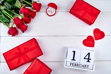 Valentines Day background with red roses, gift boxes, two hearts, diamond ring and wooden block calendar february 14, copy space. Greeting card mockup. Love concept. Top view, flat lay