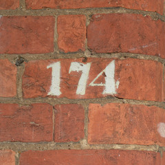 House number 174 sign painted on wall