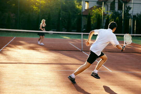 Young People Playing Tennis Outdoors