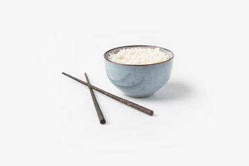 bowl of rice with chopsticks on white tabletop