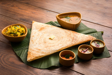 Masala dosa with chutney and sambar and potato sabzi. Cone, triangle or roll shape, selective focus
