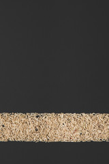stripe of raw rice isolated on black with copy space