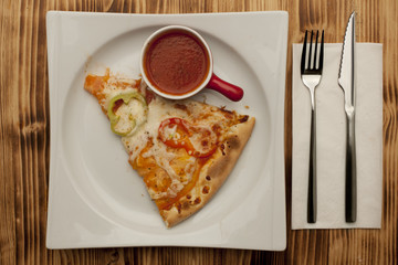 a piece of vegetarian pizza on a plate served with ketchup