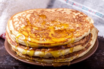 Thick pancakes with honey. Tasty and sweet pancakes