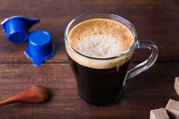 black coffee in a glass mug on a wooden table